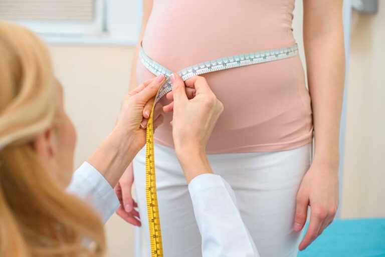 A doctor measuring a pregnant woman's stomach