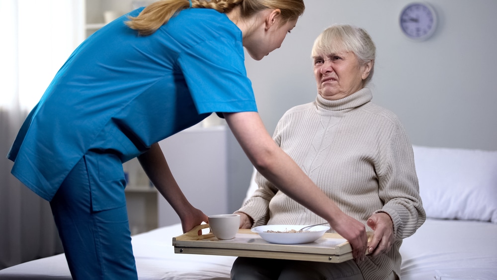 Naughty senior lady refusing disgusting diet dinner in medical center, care