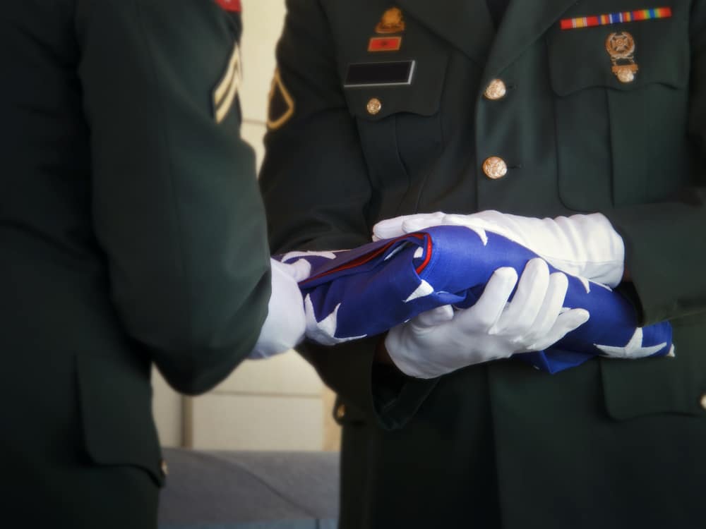 Military Honor Guard Folds United States Flag at Veteran Funeral