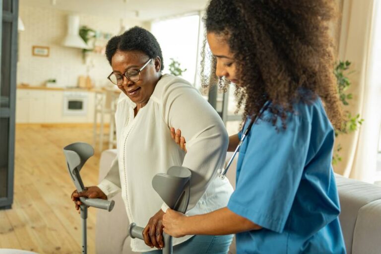 A nurse helping a senior patient stand
