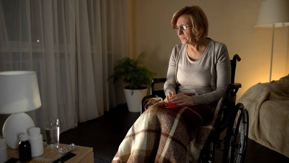 A senior lady knitting on the wheelchair