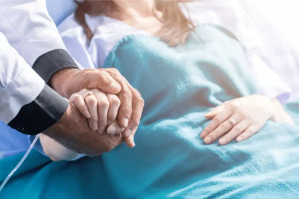 Healthcare provider holding patient's hand offering comfort and support