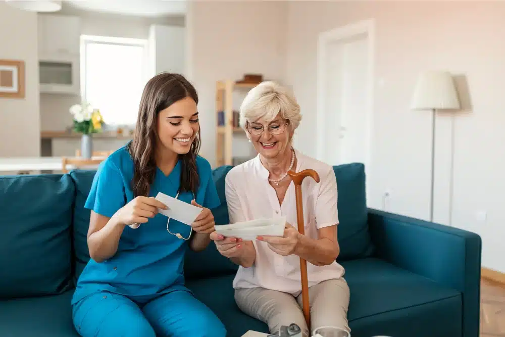 A young caregiver assisting a senior woman at home.