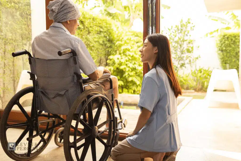 Elderly patient in a wheelchair and nursing home staff