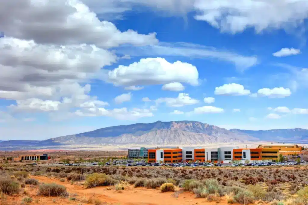 A modern building complex in an arid landscape with dramatic mountain backdrop