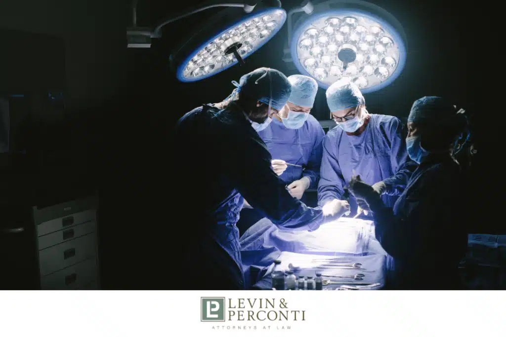 Surgical team performing operation under bright operating room lights with medical instruments