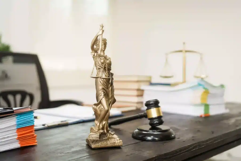 Lady Justice statue with gavel and legal documents