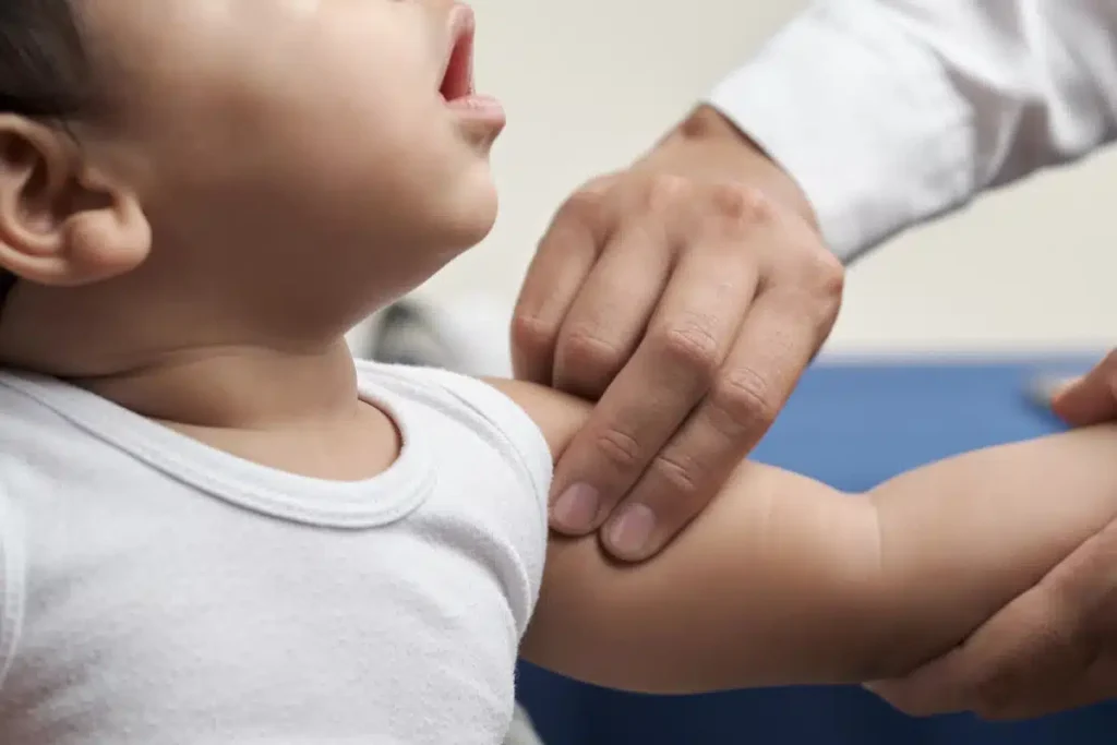 Image of the hands of a doctor examining a child.