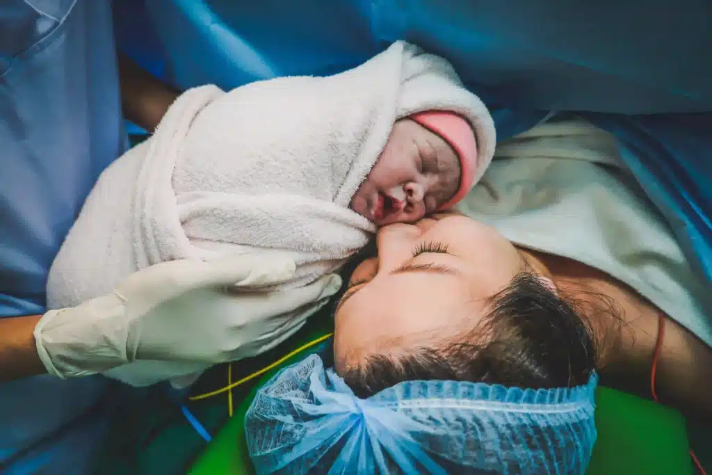 Intimate moment of a parent holding their newborn in a hospital setting