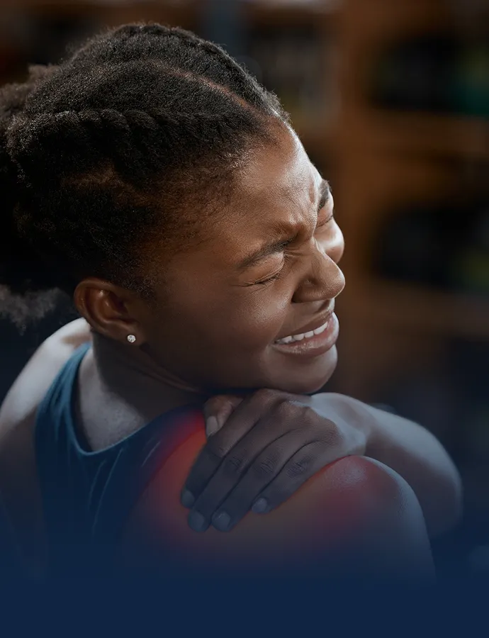 Woman holding her shoulder and wincing in pain from a personal injury