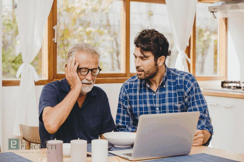 Frustrated older man and younger man with a laptop on the table in front of them