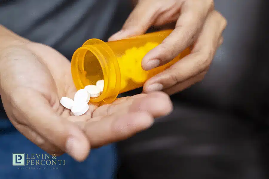Close up of patient emptying pills from a container into their hand