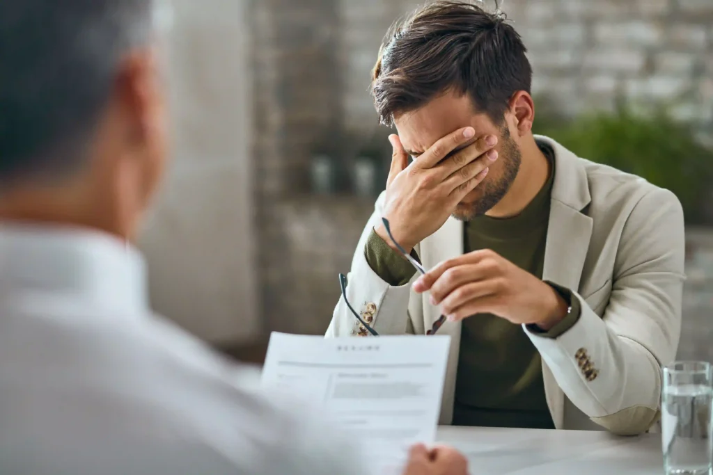 A client appearing stressed while reviewing documents during a consultation meeting with a lawyer