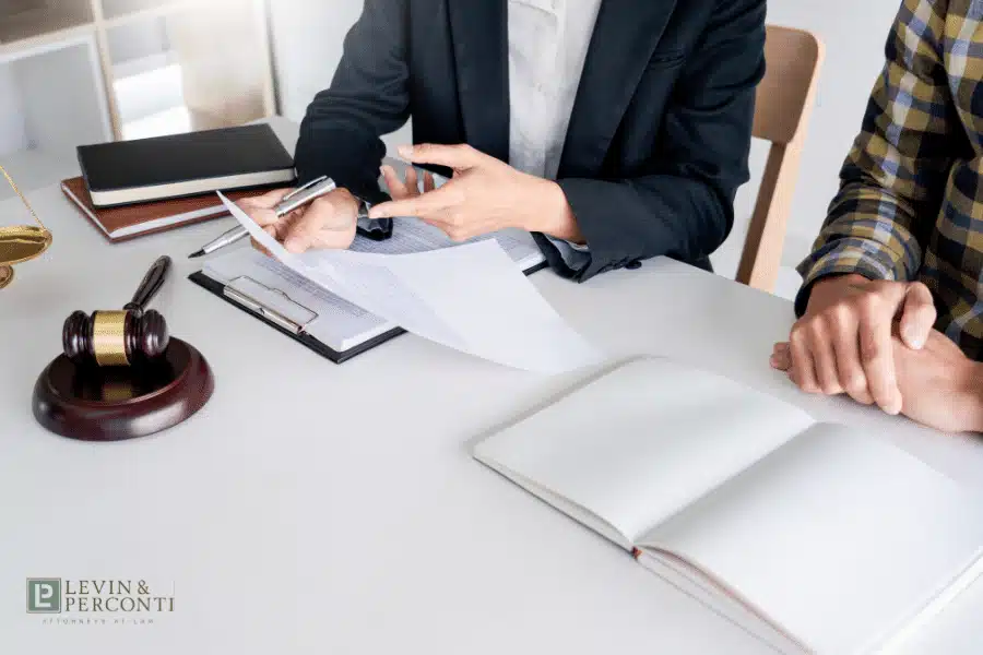 Attorney or legal professional reviewing documents with client at desk with gavel visible