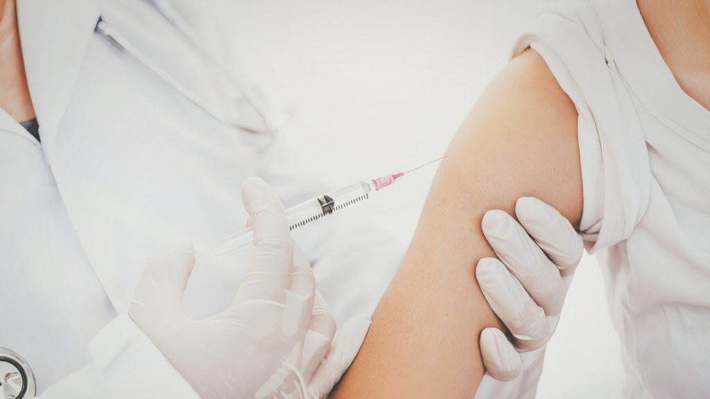 a doctor giving a patient an injection after cleaning the area with an alcohol swab