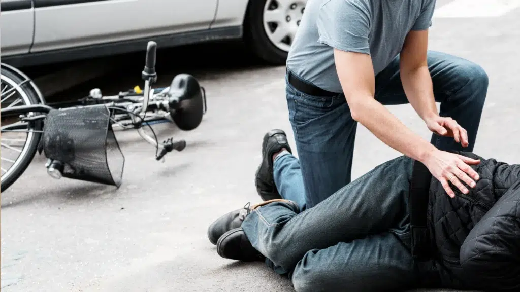 injured cyclist receiving help after a roadway accident