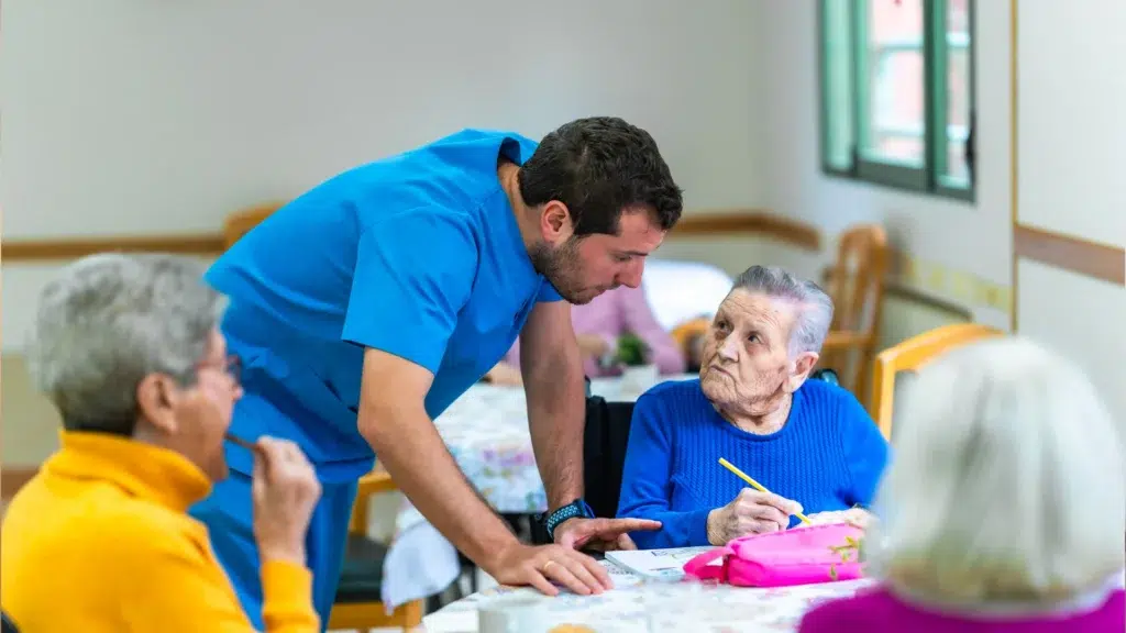 nursing home staff member interacting with elderly residents