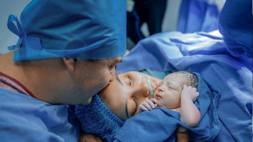 a father hugging the mother after just giving birth to their child