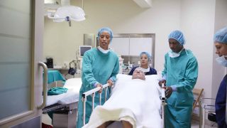 surgical team wheeling a patient out